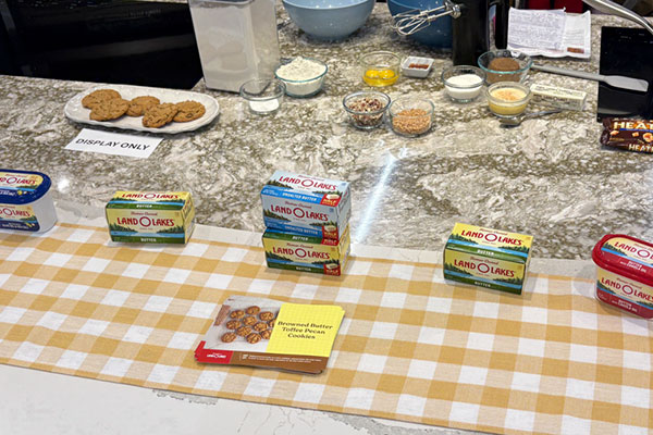 marbled countertop holding boxes of Land O Lakes butter, plate of cookies and small bowls of ingredients