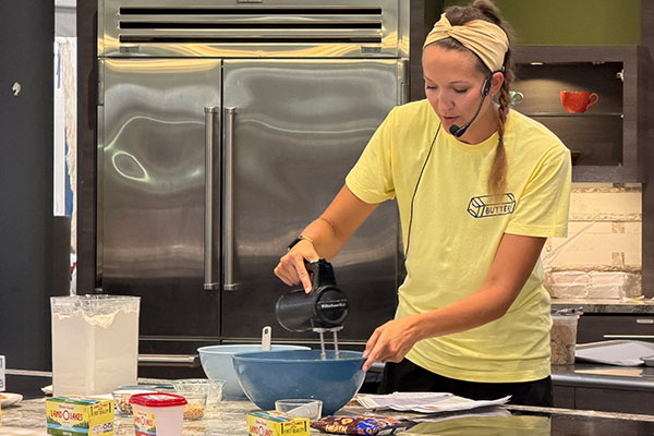 woman mixing cookie batter in demo kitchen