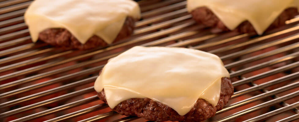 burgers on a grill with cheese